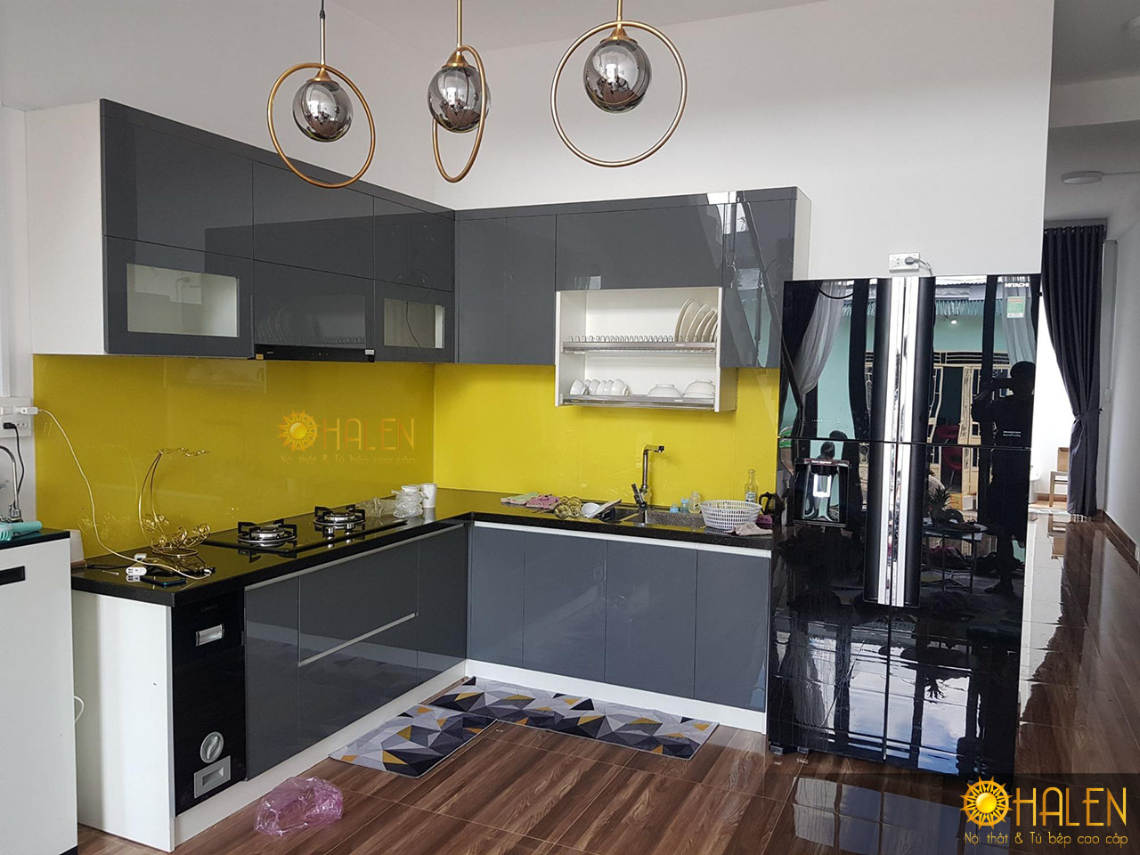 Kính bếp màu vàng là điểm nhấn cho bộ tủ bếp chất liệu Acrylic màu ghi sang trọng