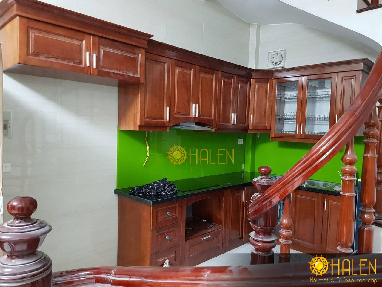 Bộ tủ bếp gỗ xoan đào màu cánh gián kết hợp với kính bếp màu xanh lá cây