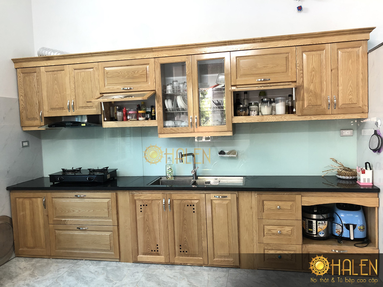Tủ bếp sồi vàng nhạt kết hợp kính bếp màu tắng xanh nhẹ nhàng, thu hút mọi ánh nhìn