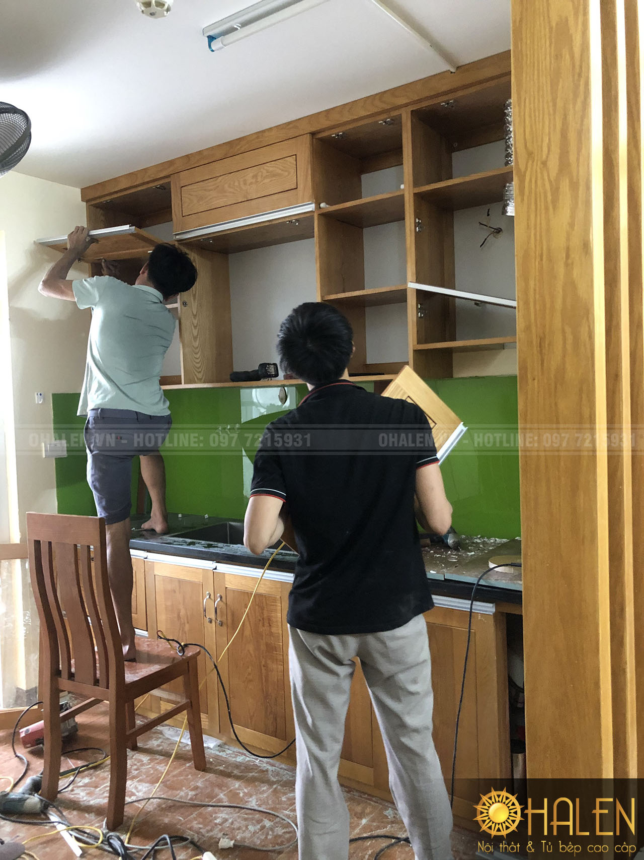 Thợ thi công đang tiến hành lắp đặt tủ bếp - chất liệu gỗ sồi tự nhiên