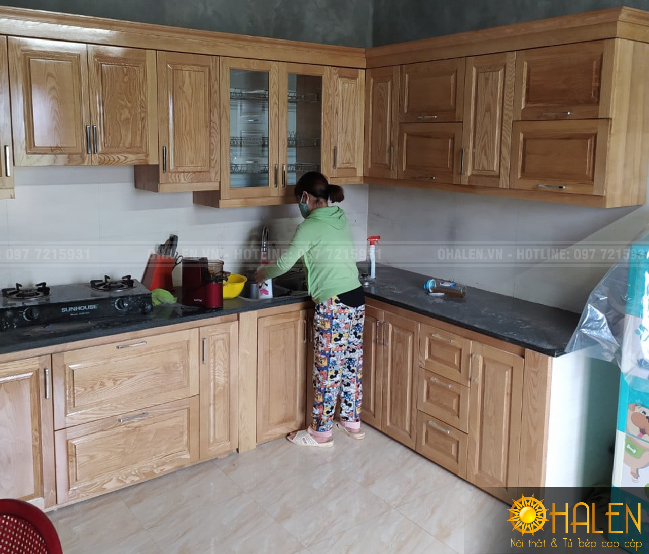 Hình ảnh chị Duyên cùng bộ tủ bếp màu vàng nhạt chất liệu gỗ sồi Nga