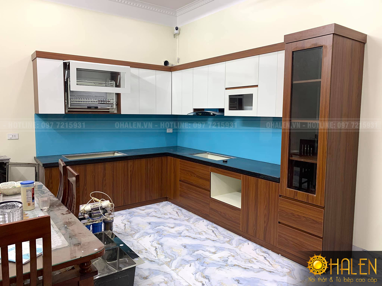 Mẫu tủ bếp Melamine màu trắng kết hợp vân gỗ tuyệt đẹp với điểm nhấn là kính ốp bếp màu xanh dương